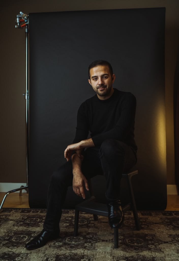William Kasel seated in a photography studio